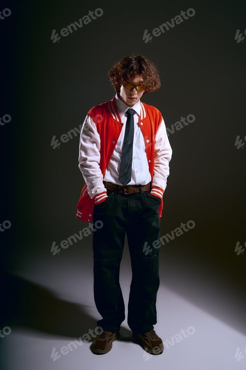 Preview: Emotional young man in stylish attire showcases curly hair and unique fashion sense