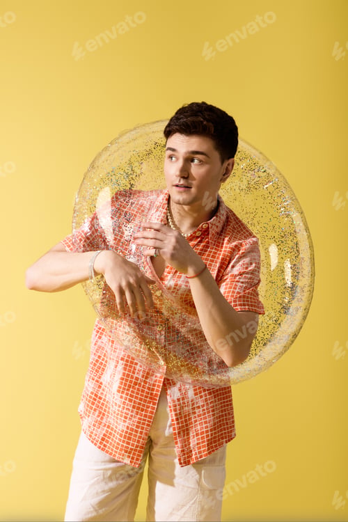 Preview: Stylish young man enjoying summer vibes with a playful bubble in a vibrant setting