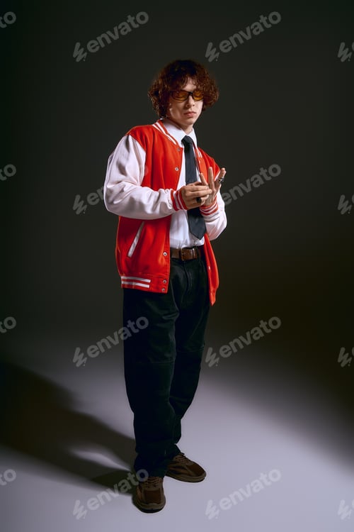Preview: Young emotional man showcases stylish outfit against a dramatic backdrop with vibrant confidence