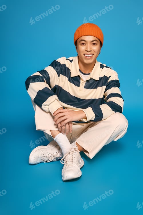 Preview: Daring young man expresses vibrant fashion in a studio setting with striking colors
