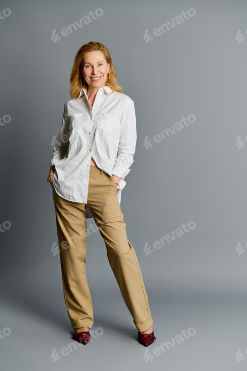 Preview: Elegant mature woman in stylish outfit exudes confidence and grace in a modern setting