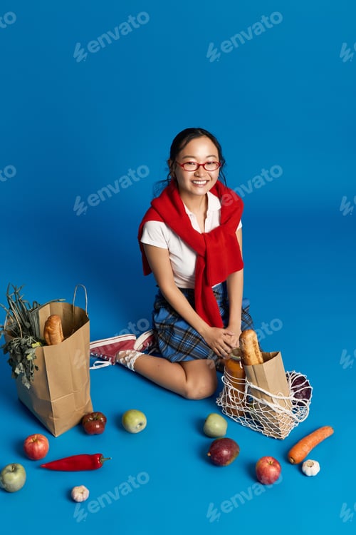 Preview: Charming young woman enjoys vibrant market day with fresh groceries and stylish flair