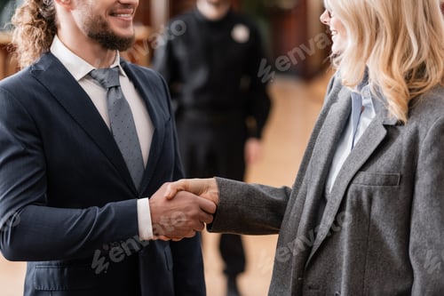 Preview: Cropped View of Smiling Advocate Shaking Hands With Happy Businessman in Court