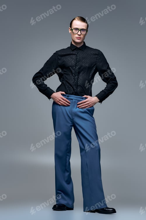 Preview: Young man showcases modern fashion style in studio environment with confidence