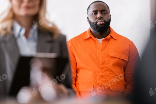 Preview: African American Man in Orange Jail Uniform Near Advocate on Blurred Foreground