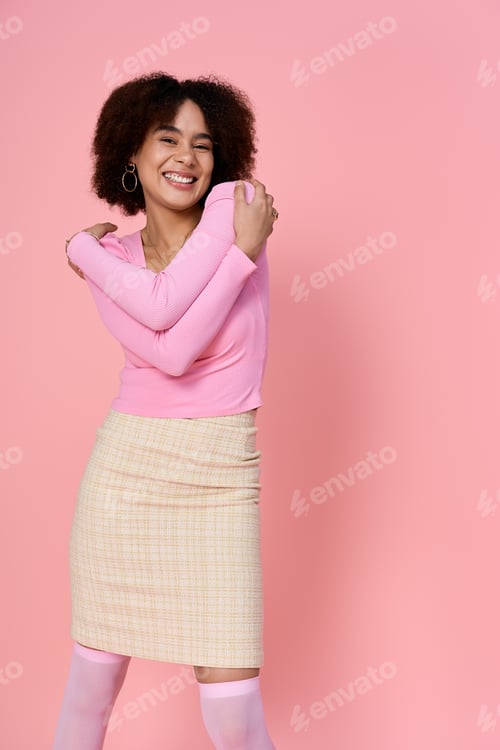 Preview: Charming young woman exudes joy in stylish pink attire against a vibrant backdrop