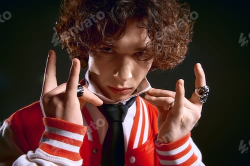 Preview: Handsome young man with curly hair exudes emotion in stylish street fashion attire