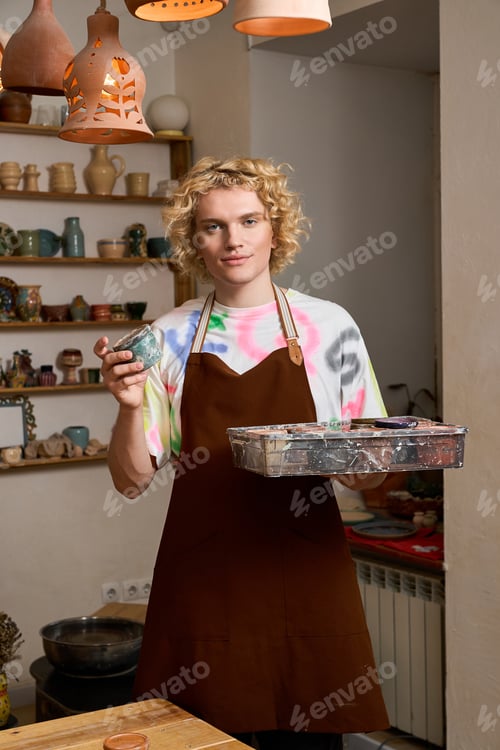Preview: Young artisan shaping clay in a pottery workshop filled with creativity and joy