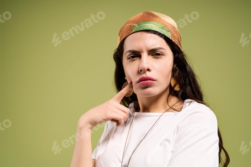 Preview: Stylish young woman showcases vibrant summer fashion in green studio setting