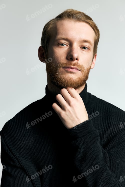 Preview: Handsome stylish man in a black turtleneck poses with confidence against a light background
