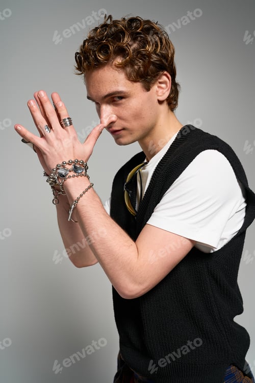 Preview: Stylish young man expresses unique fashion sense in trendy studio setting