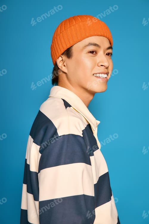 Preview: Stylish asian young man showcasing modern fashion in vibrant studio setting