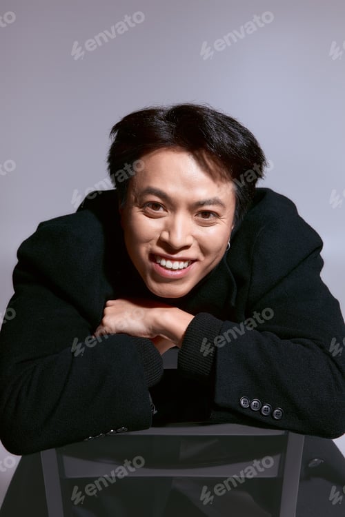 Preview: Stylish young man expresses modern fashion in a vibrant studio setting