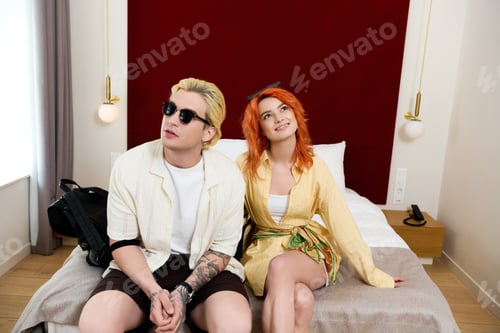 Preview: Beautiful couple enjoying a summer getaway in a modern hotel room together