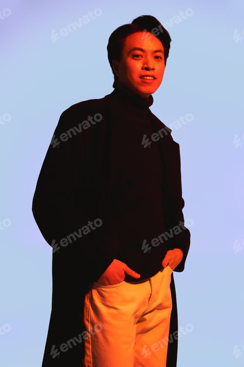 Preview: Stylish young man showcases modern fashion trends in studio setting