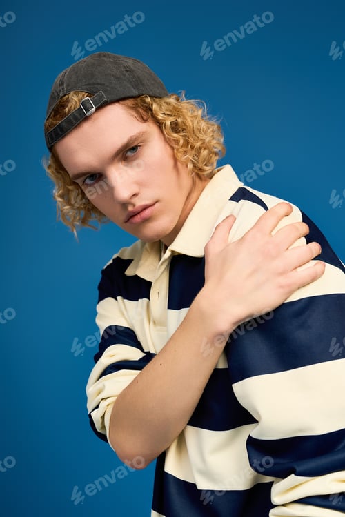 Preview: Young man showcasing fashion with a stylish look in a vibrant studio space
