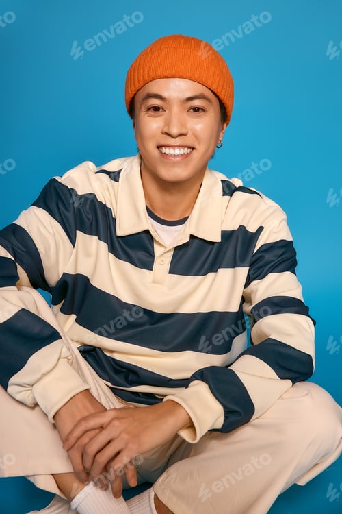 Preview: Stylish young asian man displaying unique fashion in vibrant studio setting