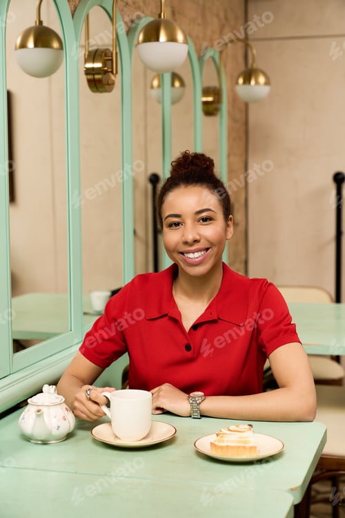 Preview: Joyful moments captured in a vibrant cafe with a young woman enjoying her drink