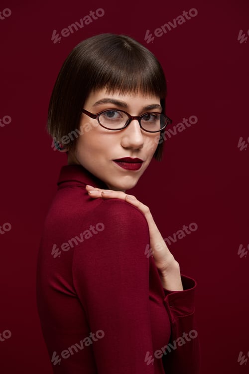 Preview: Fashionable woman showcases bold style in a rich burgundy setting full of elegance and charm