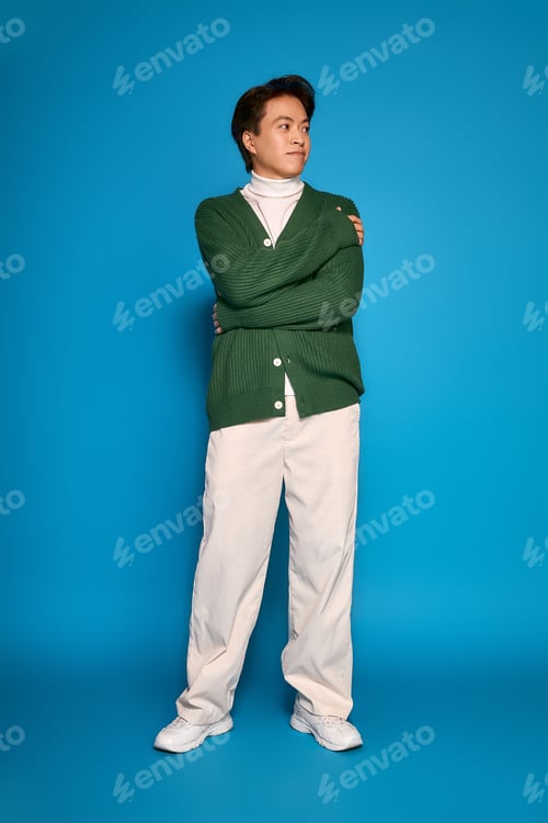 Preview: Young Asian man displays unique fashion style in vibrant studio setting