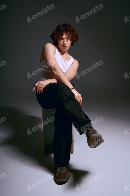 Preview: Emotional young man with curly hair poses stylishly in an artistic setting