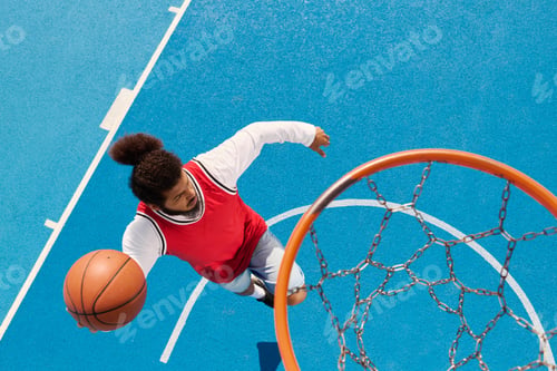 Preview: Young man showcases skills on vibrant outdoor basketball court in thrilling game moment