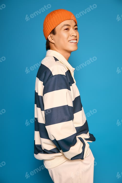 Preview: Stylish asian young man expressing fashion creativity in modern studio setting