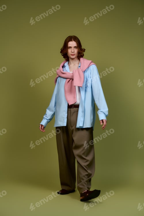 Preview: Stylish young man showcasing contemporary fashion trends in a vibrant studio setting