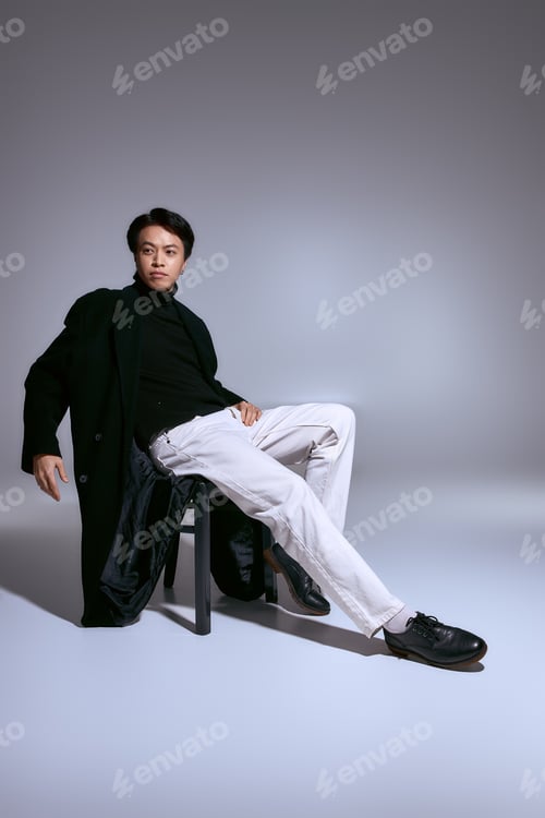 Preview: Stylish asian young man displays unique fashion sense in sleek studio setting