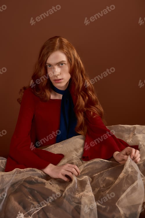 Preview: Handsome young man with flowing red hair showcases elegance in modern fashion