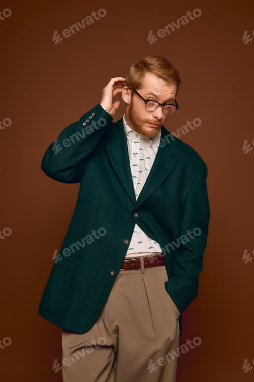 Preview: Handsome red haired man exudes charm in stylish attire against a warm backdrop