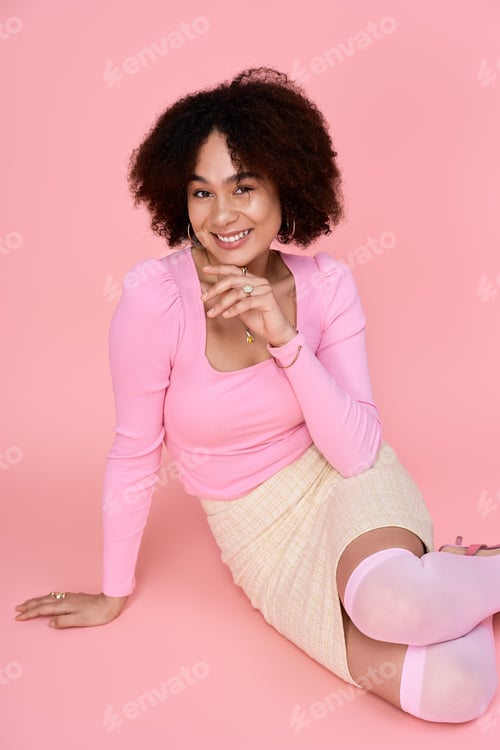 Preview: Bright and cheerful young woman exudes style and confidence against a playful pink backdrop