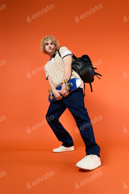 Preview: Young student showcases trendy style in a vibrant studio setting with skateboard