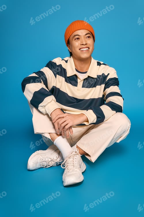 Preview: Stylish young asian man expresses fashion creativity in vibrant studio setting