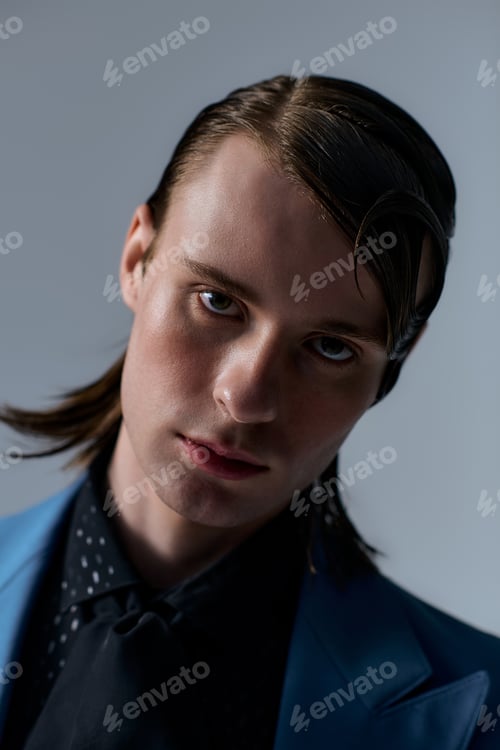 Preview: Stylish young man showcases modern fashion in creative studio setting
