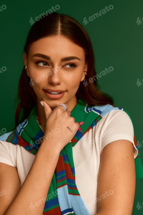 Preview: Fashion forward young woman posing in stylish outfit against vibrant green backdrop