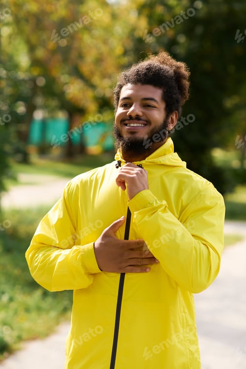 Preview: Young man enjoys spring workout outdoors in a vibrant yellow windbreaker jacket