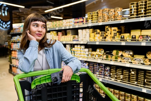 Preview: Young woman enjoys a stylish shopping experience in a vibrant supermarket environment