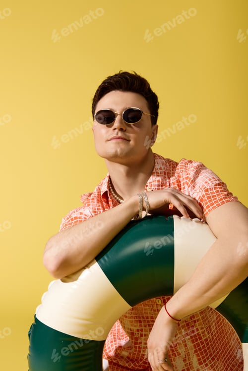 Preview: Stylish young man enjoying summer vibes with a playful twist in vibrant sunshine