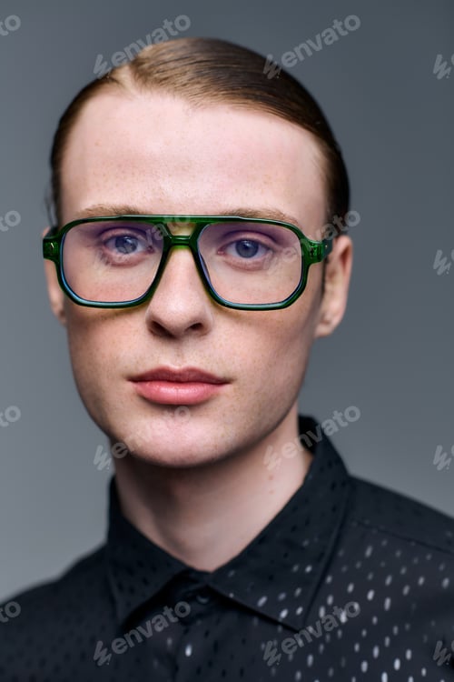 Preview: Young man showcases modern fashion in a chic studio with striking glasses