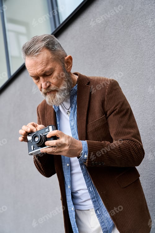 Preview: Senior man with a beard captures urban moments on a lively city street
