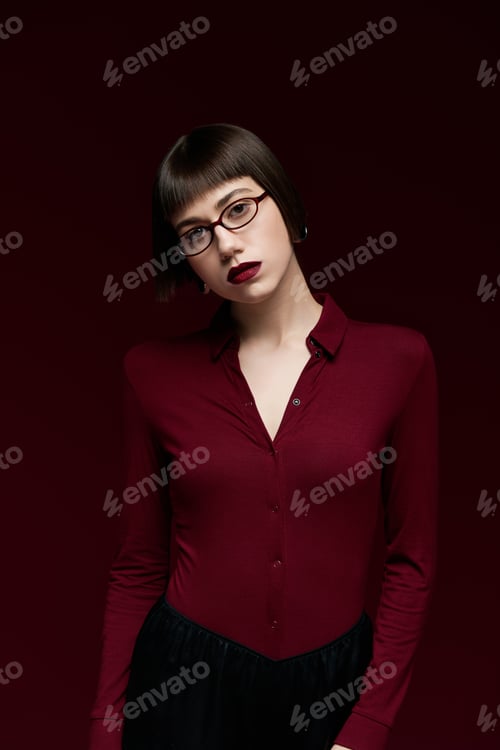 Preview: Elegant young woman showcases modern fashion in rich shades against a bold backdrop