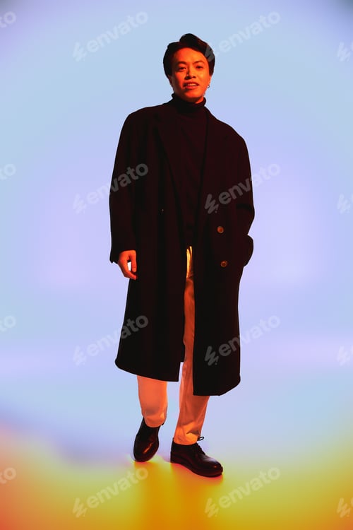 Preview: Stylish young Asian man expresses contemporary fashion trends in vibrant studio setting