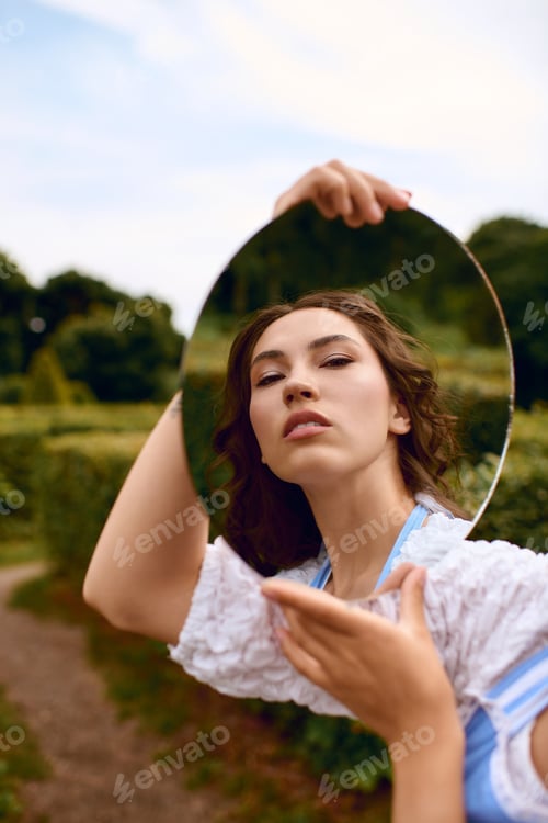 Preview: Enchanting woman exploring a whimsical realm of nature with a reflective mirror in hand