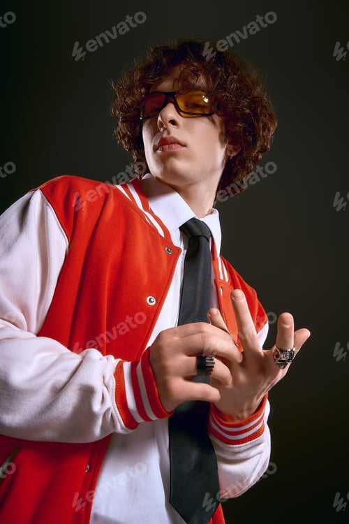 Preview: Young man expressing emotion in stylish outfit with curly hair and unique accessories