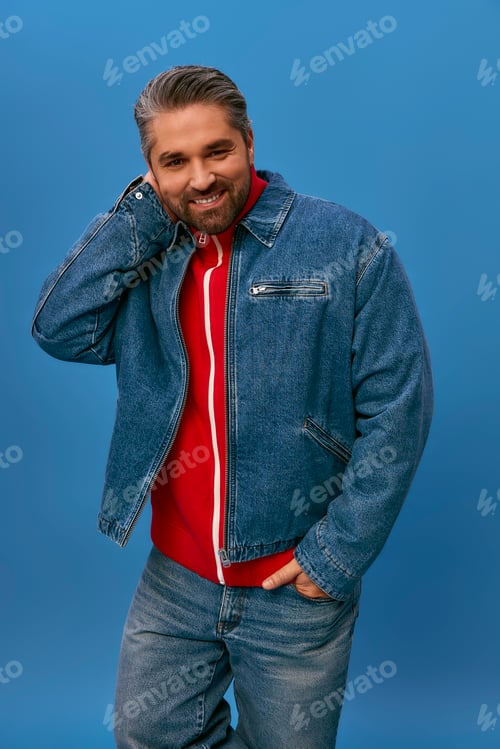Preview: Stylish adult man poses confidently against a vibrant blue backdrop