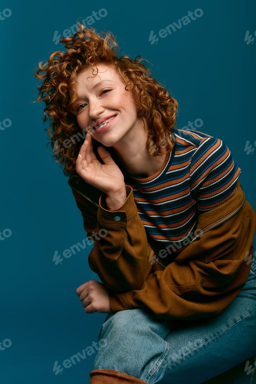 Preview: Stylish young woman with curly hair showcases modern fashion while smiling brightly