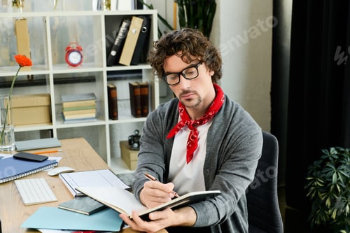 Preview: Handsome young man working diligently in a modern office setting with a creative flair