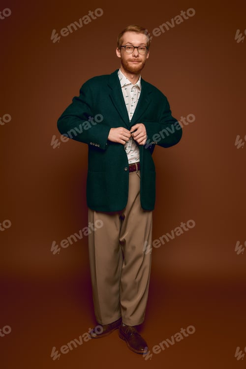 Preview: Handsome red haired man showcases stylish attire with confidence in a modern setting