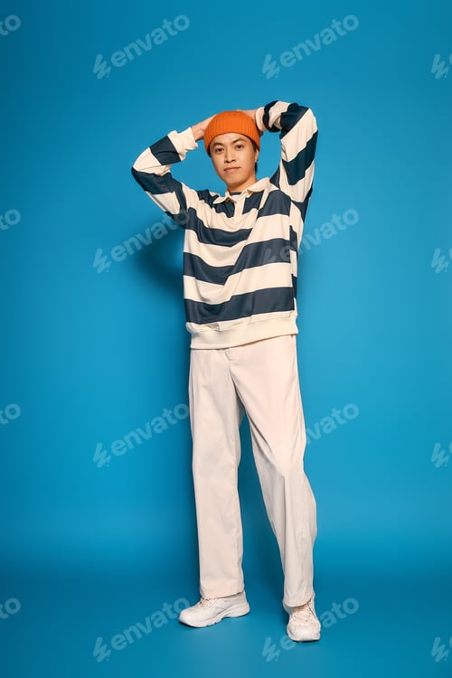 Preview: Stylish young asian man expresses his unique fashion sense in a vibrant studio setting